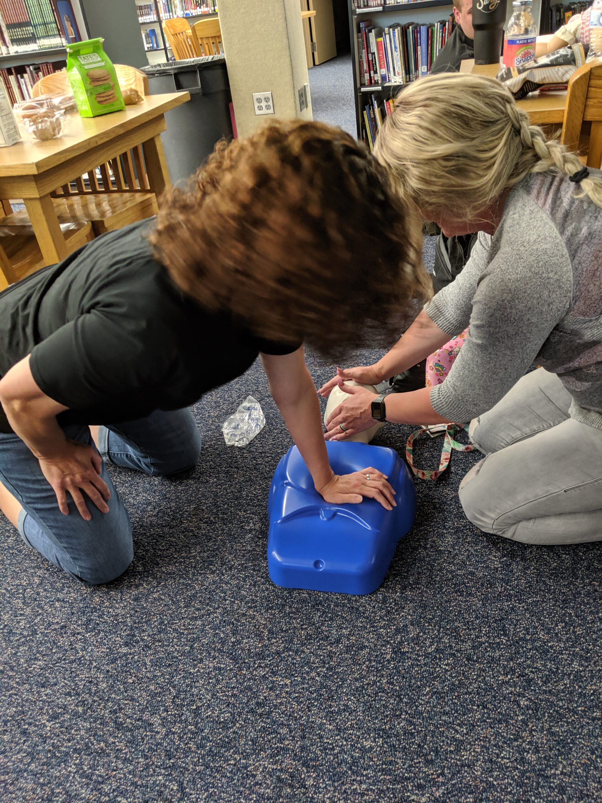 Teachers performing CPR on a manikin